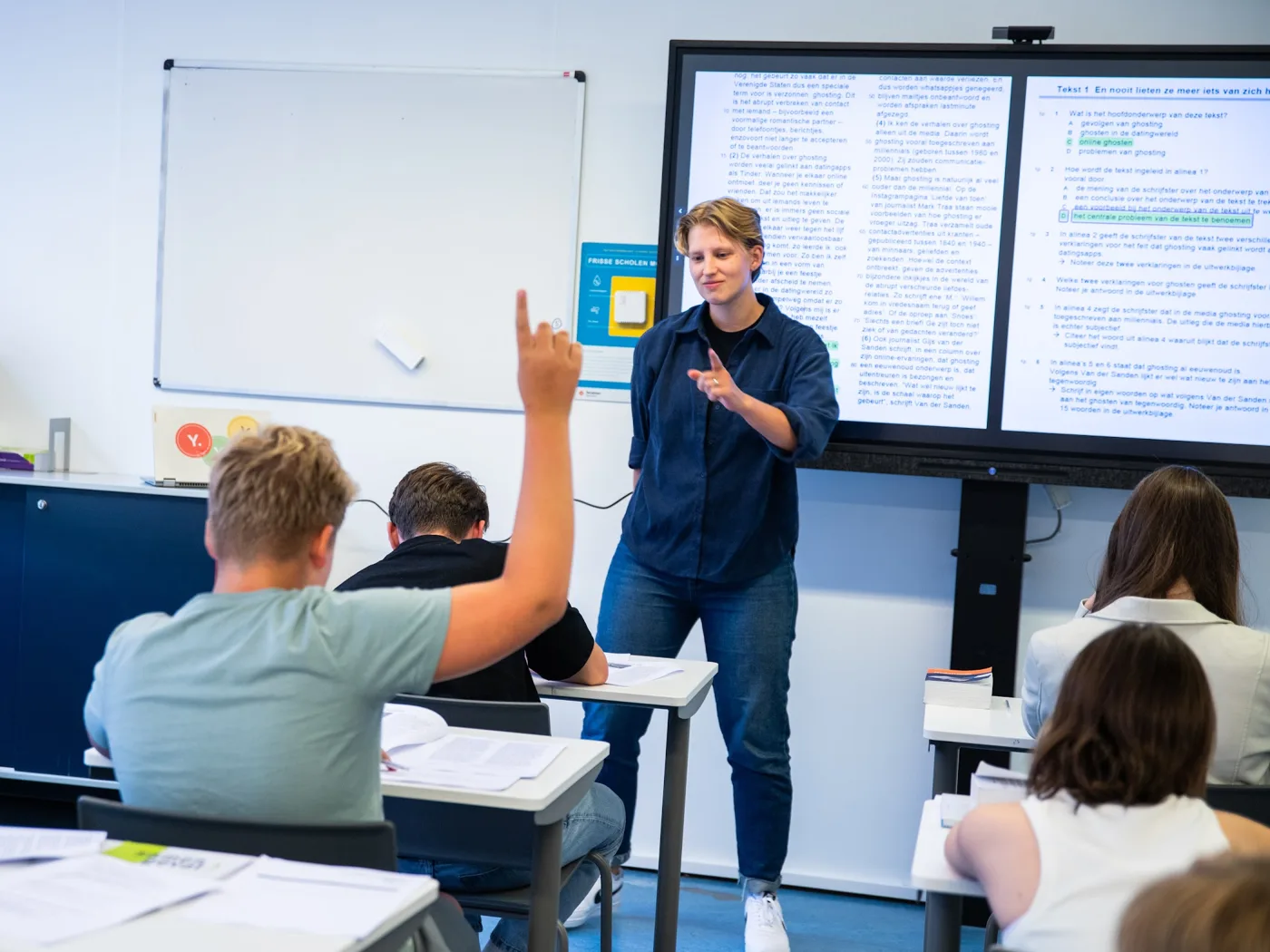 Een Yepper geeft uitleg aan examenkandidaten bij het digibord